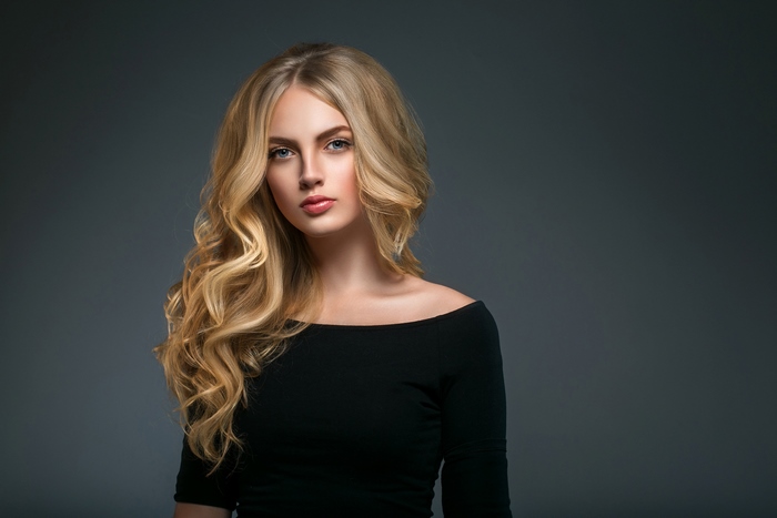 Blonde woman with blue eyes and long wavy hair