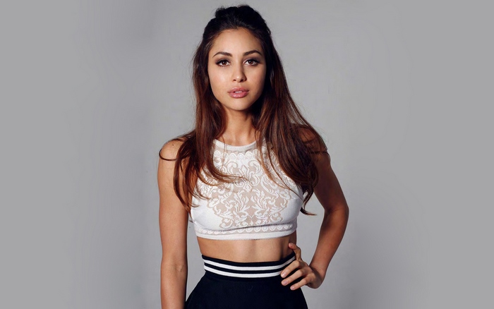 Lindsey Morgan posing in a white top and black skirt