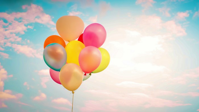 Colorful balloons floating in a cloudy sky