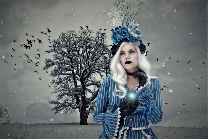 Woman in blue dress with white hair and blue roses in hat in winter