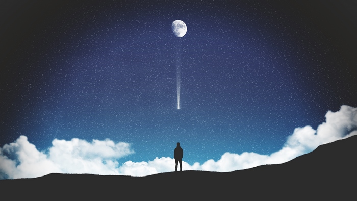 Silhouette of a person watching a meteor shower under the moon