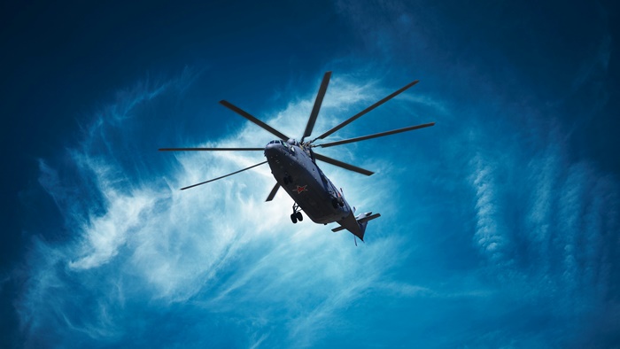 Military helicopter flying in a blue sky