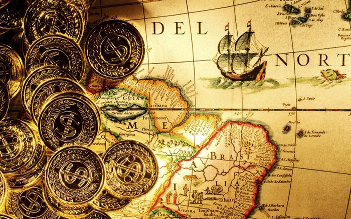 Gold coins on an old map with a ship