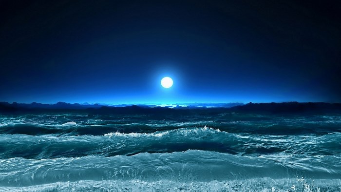Ocean waves under a bright moon