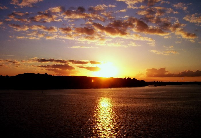 Sunset over water with clouds
