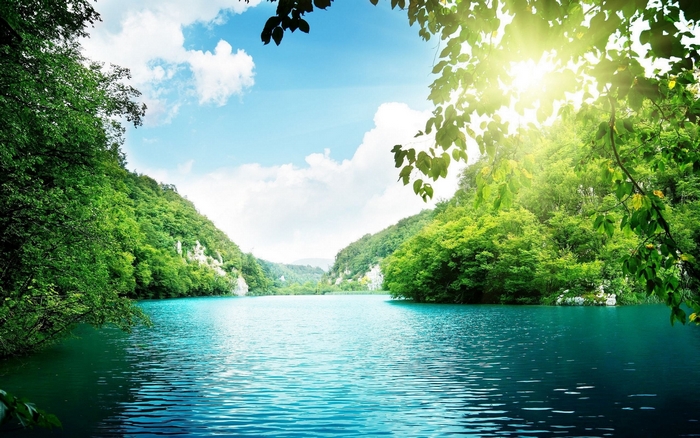 Turquoise lake surrounded by green forest and mountains