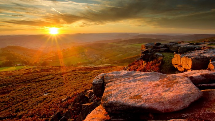 Sunset over rolling hills and rocky outcrop