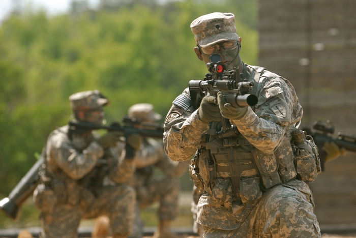 Soldiers in camouflage aiming rifles