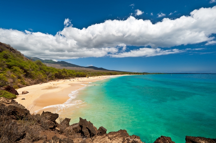Beach with turquoise water and green hills in Hawaii