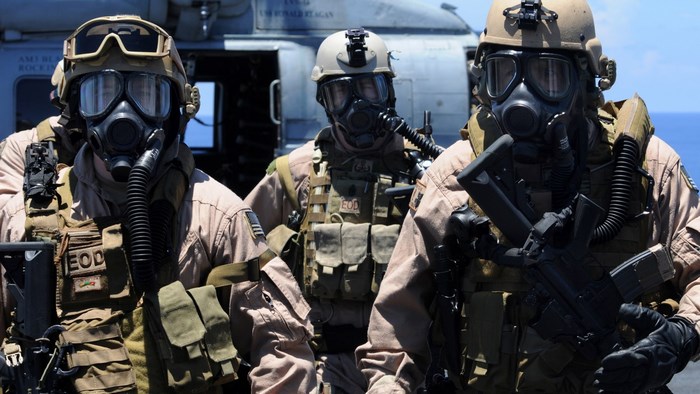 Three soldiers in gas masks and tactical gear