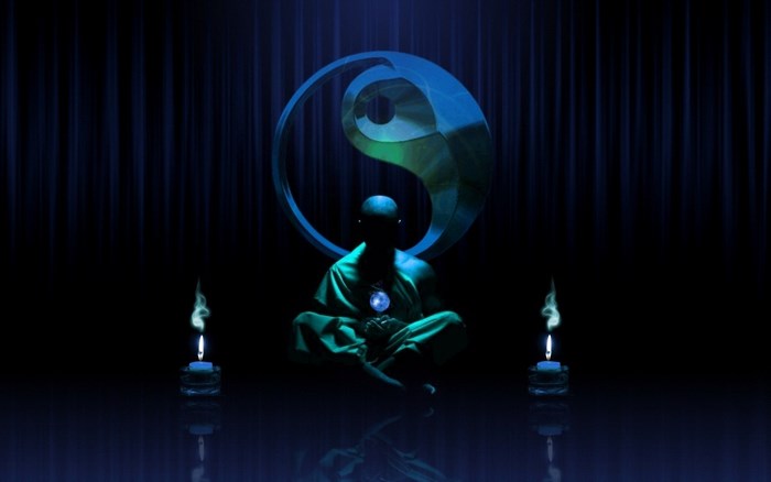 Monk meditating with Yin Yang symbol and candles