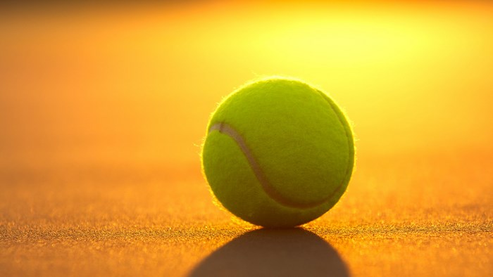 Tennis ball on court at sunset