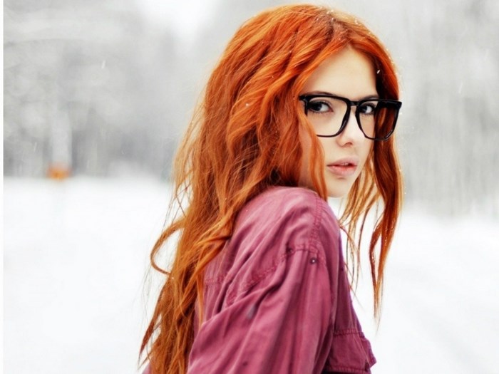 Woman with red hair and glasses in snow