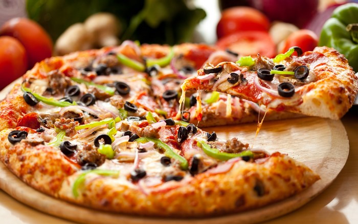 Delicious pizza with toppings on a wooden board