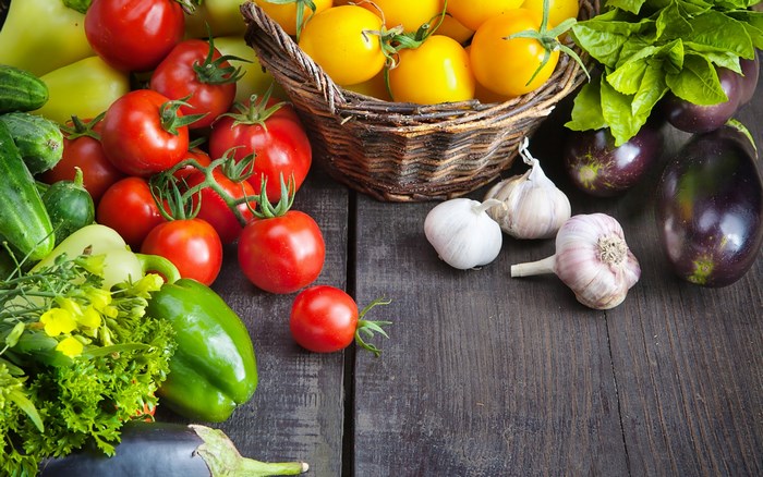 Assortment of fresh vegetables and garlic on wooden table