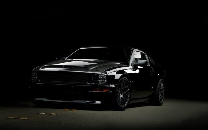 Black Ford Mustang parked on asphalt