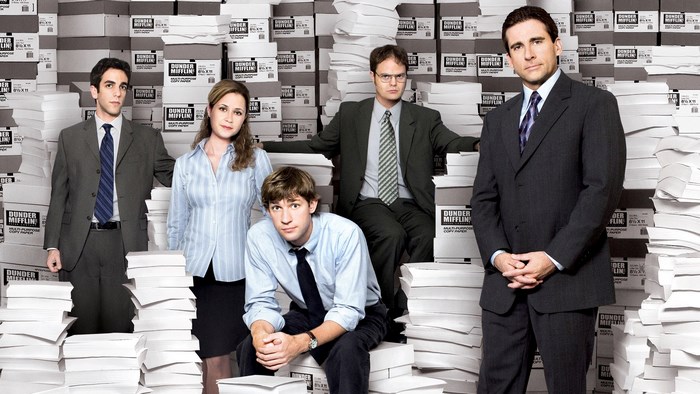 The Office US cast with Dunder Mifflin paper