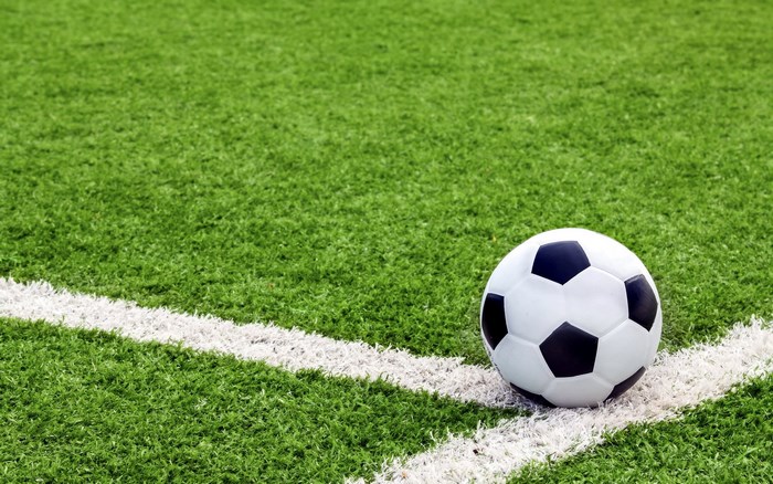 Soccer ball on a green field with white line