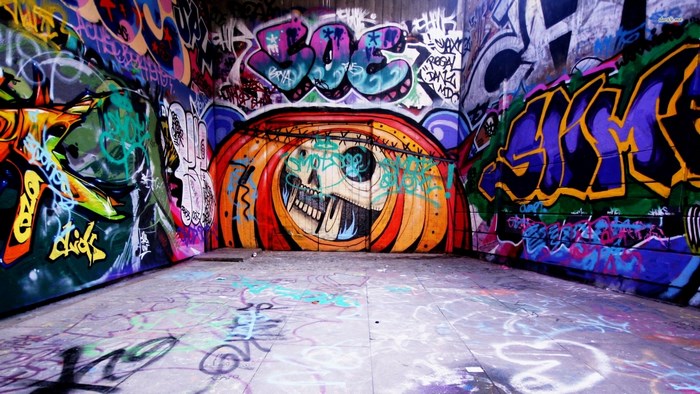 Graffiti-covered tunnel with skull mural
