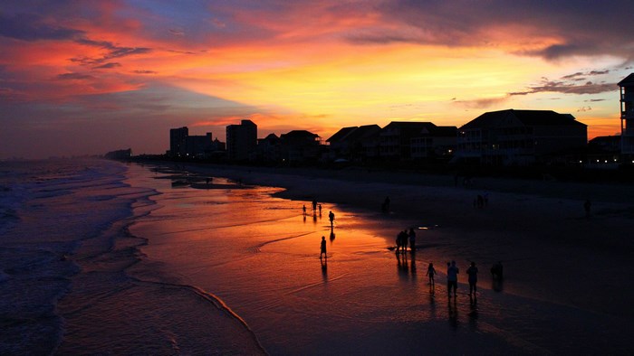 Beach sunset with people and buildings