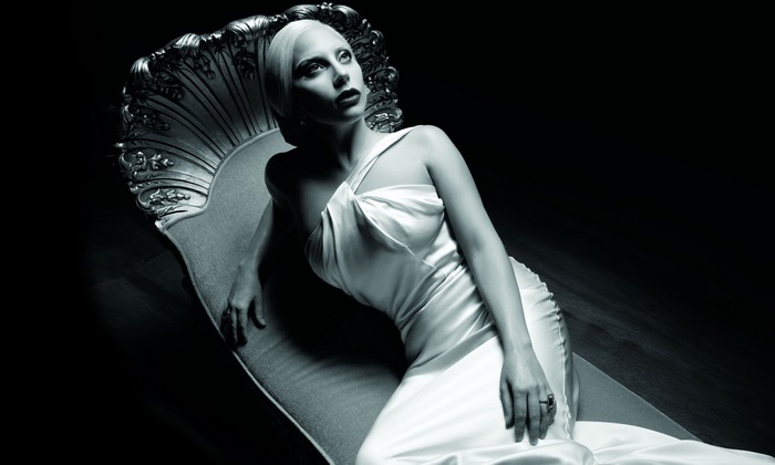 Lady Gaga in a white dress on a chaise lounge