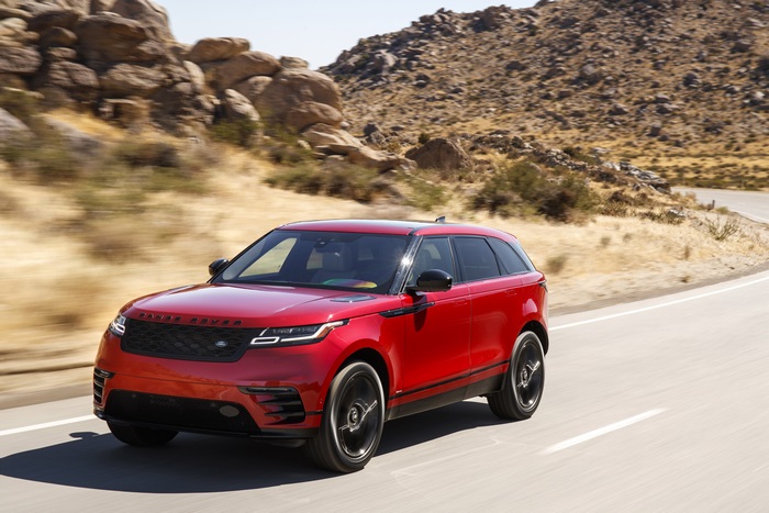 Red Range Rover Velar driving on a desert road