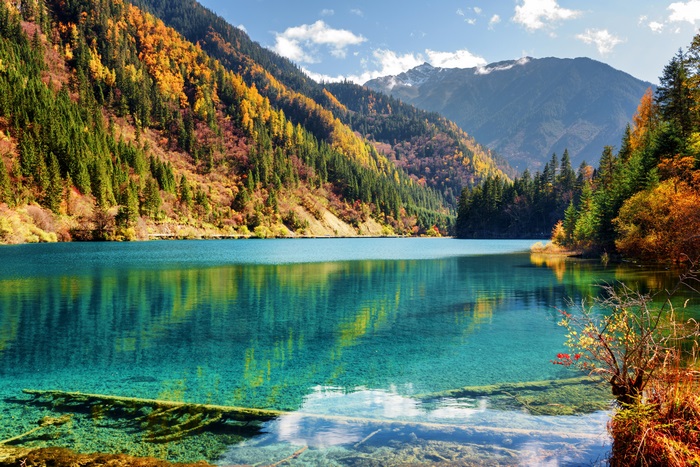 Turquoise lake surrounded by autumn forest and mountains