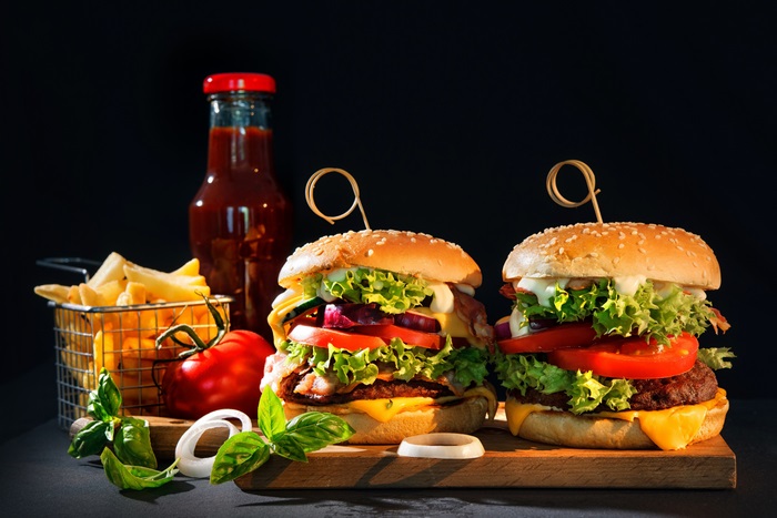 Two gourmet burgers with fries and ketchup