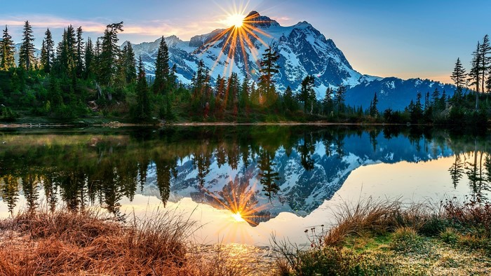 Mountain lake with sun rays reflecting on water