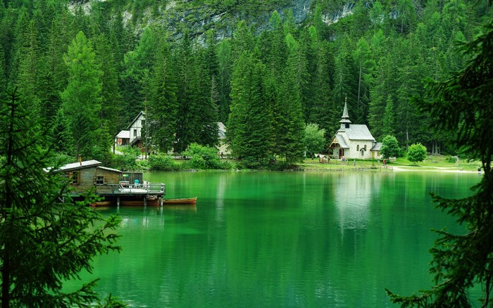 Lake with church and boathouse in a forest