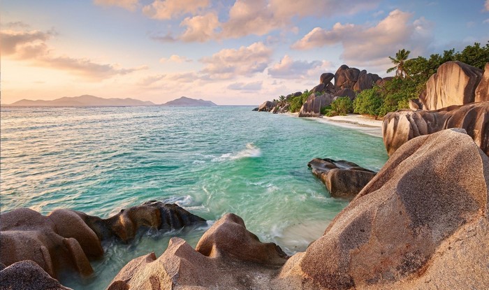 Tropical beach with granite boulders and turquoise water at sunset