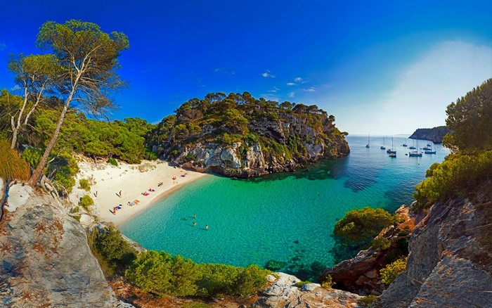 Beautiful beach with turquoise water and boats in Spain