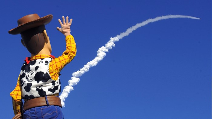 Sheriff Woody from Toy Story waving at a rocket launch