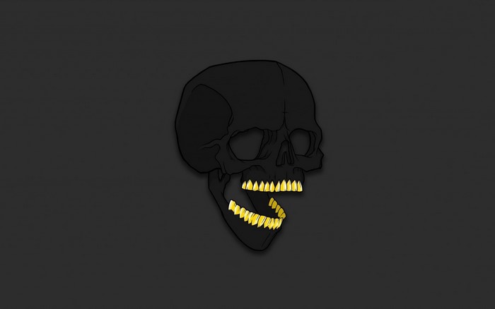 Black skull with gold teeth on dark background