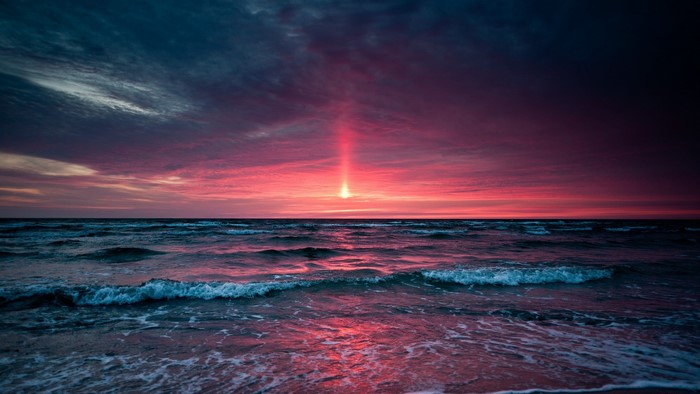 Sunset Over Ocean Waves with Vibrant Red Sky
