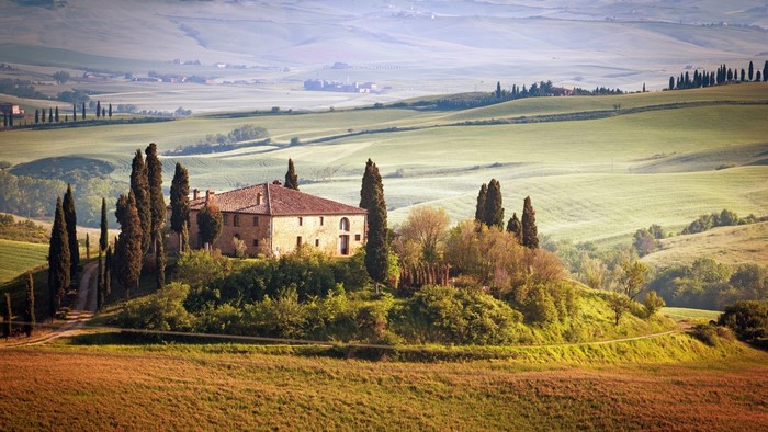 Tuscan landscape with a house and cypress trees