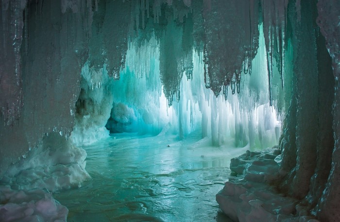 Ice cave with icicles and frozen water