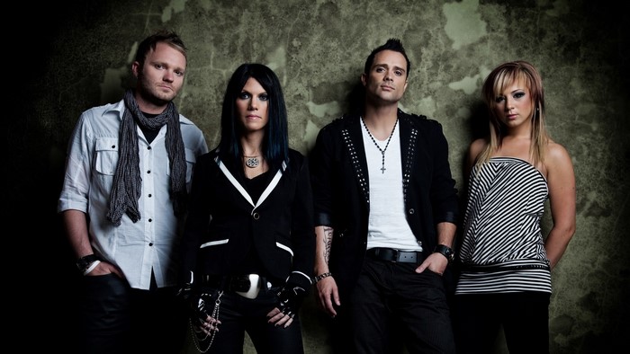 Skillet band members posing against a textured wall