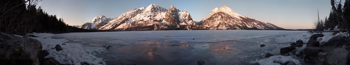 Snow-capped mountains over a frozen lake in winter