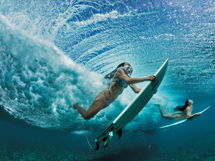 Two women surfing underwater