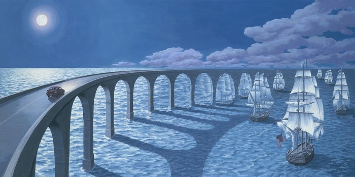 Car on a bridge over sailing ships at night