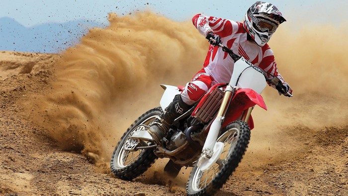 Motocross rider on a Honda CR kicking up dirt