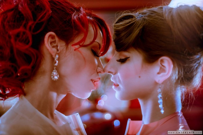Intimate Moment Between Two Women in Elegant Attire
