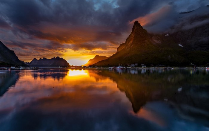 Sunset over a Norwegian fjord with mountains and reflection