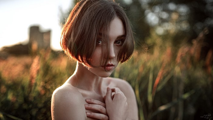 Woman with short hair in a field at sunset