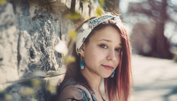 Woman with red hair and tattoos wearing a bandana
