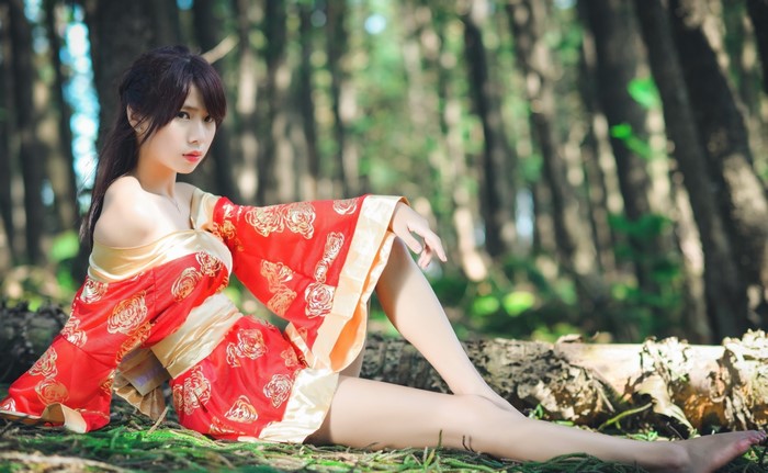 Asian woman in traditional Japanese kimono in forest