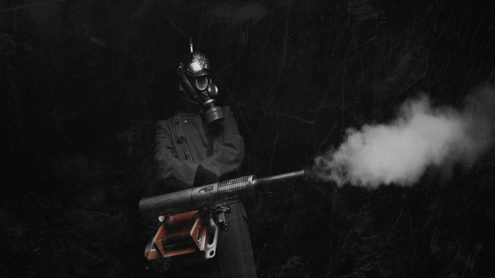 Soldier in gas mask and helmet with flamethrower