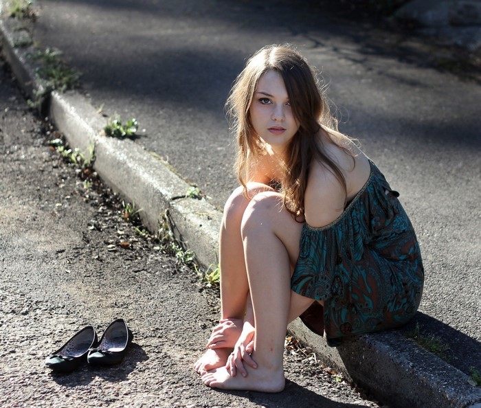 Imogen Dyer sitting on curb with shoes off