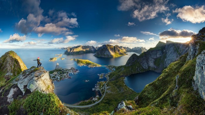 Person on mountain overlooking Lofoten islands, Norway